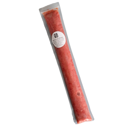 Packaged smoothie pop with visible red fruit pieces, labeled as 'Black Currant Banana'.